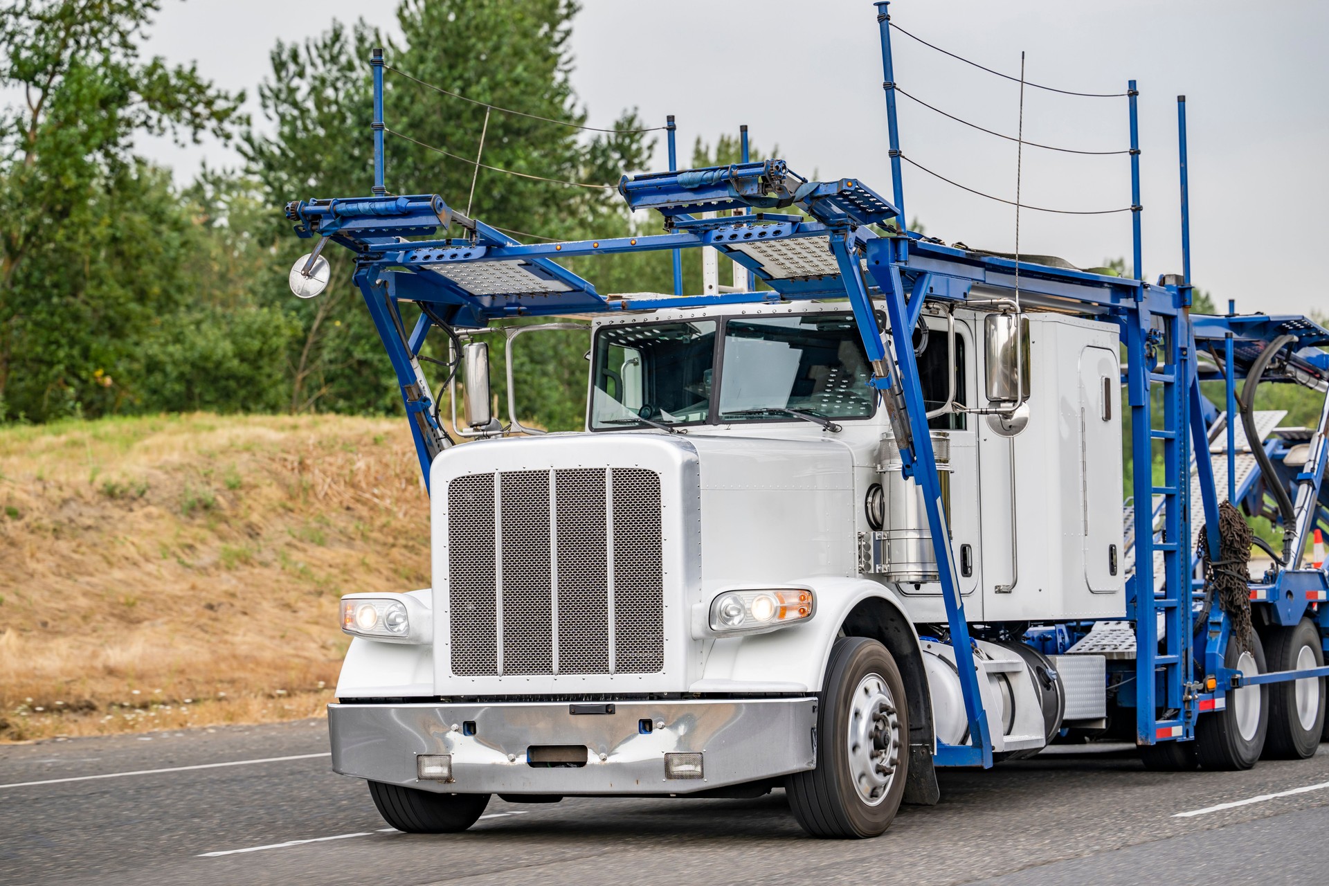 Popular industrial standard car hauler big rig semi truck with two level modular empty semi trailer running to warehouse for the next load