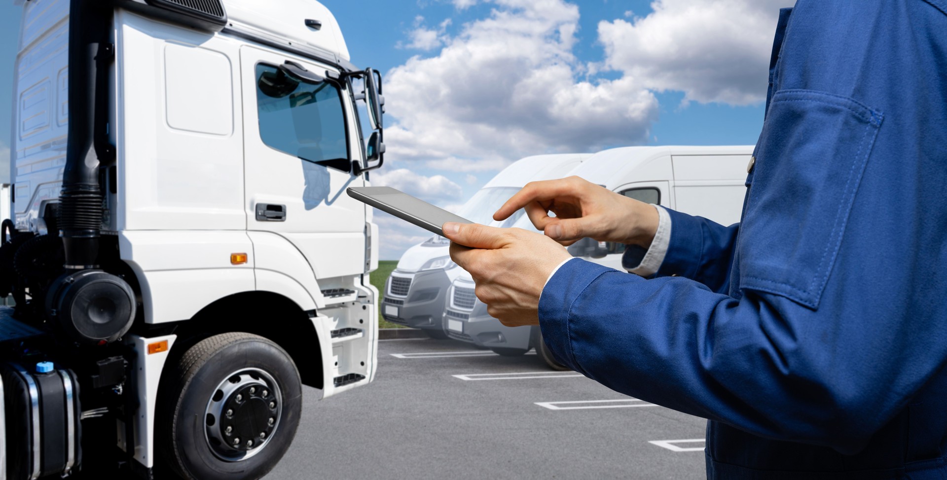 Manager holds a digital tablet in his hands nearly of trucks. Concept of fleet management. Close up of male hands with digital tablet.